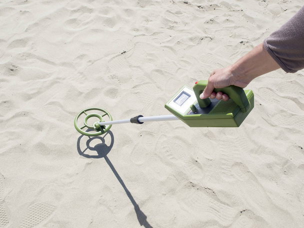 detector de metales en busca de tesoros en una playa de arena
 - Foto, Imagen