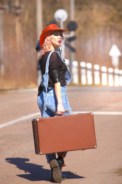 beautiful sexy woman walking on the road with a retro suitcase - Photo, image
