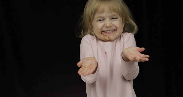 Παιδί μετά την κατανάλωση λιωμένη σοκολάτα και σαντιγί. Βρώμικο πρόσωπο - Φωτογραφία, εικόνα