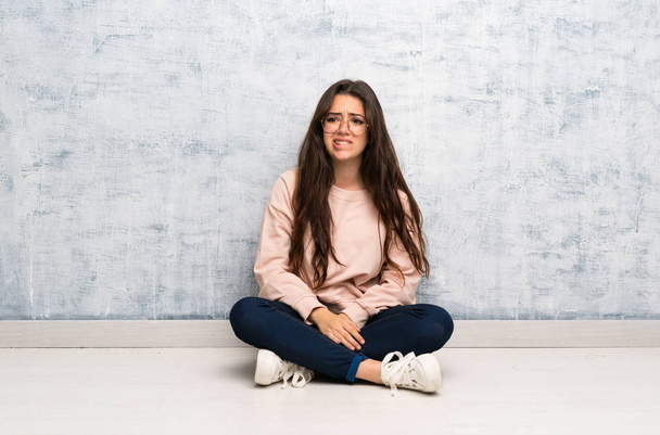Adolescente estudante menina estudando em uma mesa com expressão facial confusa
 - Foto, Imagem