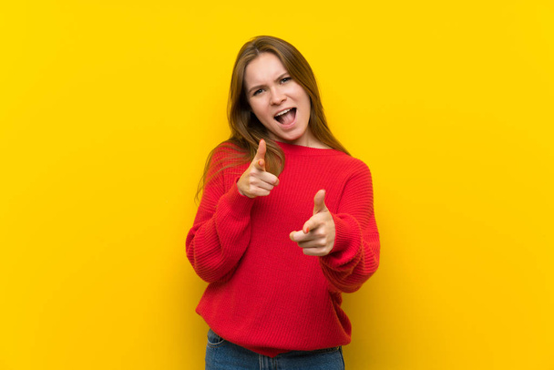 Young woman over yellow wall pointing to the front and smiling - Foto, Imagen
