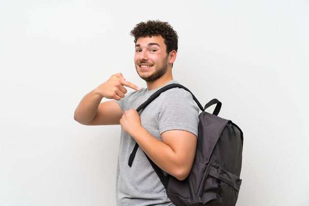 Man with curly hair over isolated wall with backpack - Foto, imagen