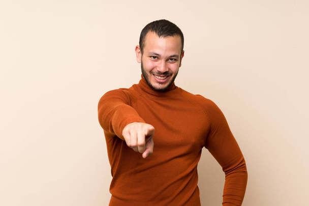 Колумбиец в свитере в водолазке указывает пальцем на тебя с уверенным выражением лица
 - Фото, изображение