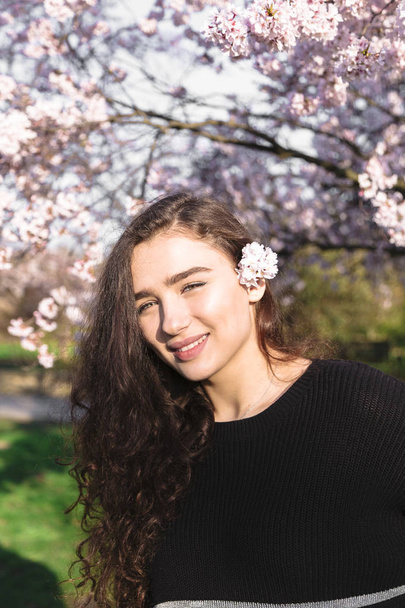 Lány áll a háttérben a cseresznye virágok fa - Fotó, kép