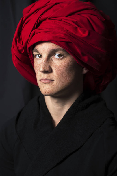 Man in bathrobe and red turban looks at camera - Foto, Imagen