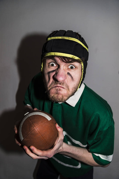 Giocatore di rugby con palla che guarda arrabbiato con la fotocamera
 - Foto, immagini