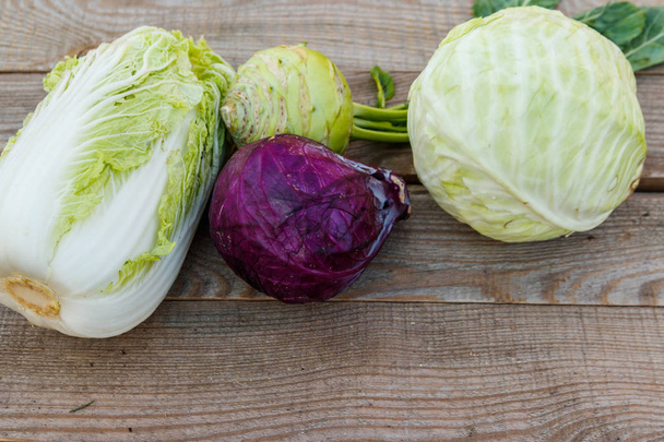 Several kinds of cabbage on rustic wooden table. Top view - Photo, Image