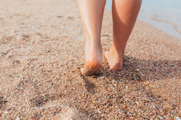 Γυναίκα περπατά στην παραλία στην άμμο  - Φωτογραφία, εικόνα