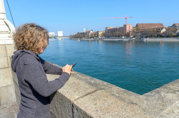 Женщина с мобильным телефоном на набережной
 - Фото, изображение