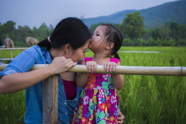 jonge moeder knuffelen en kalmeren een huilende kleine dochter, Azië - Foto, afbeelding