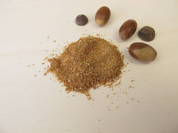 Acorn flour and acorns on a wooden board - Foto, imagen