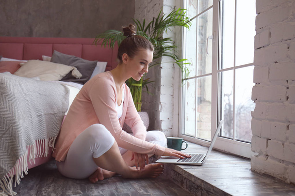 Gyönyörű fiatal nő, laptop otthon pihen - Fotó, kép