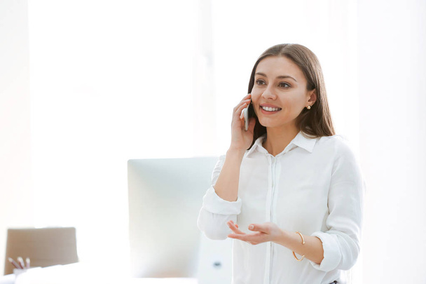 Бізнес-леді розмовляють по мобільному телефону в офісі
 - Фото, зображення