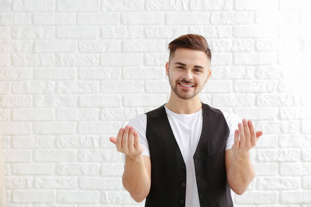 Handsome man showing "come here" gesture on white background - Fotó, kép