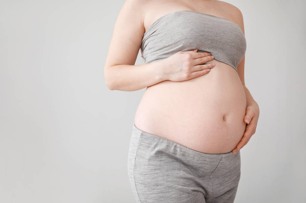 Schöne schwangere Frau auf hellem Hintergrund - Foto, Bild