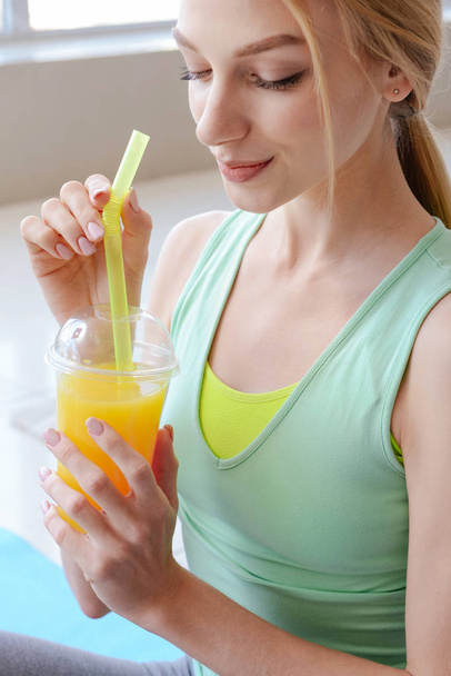Desportivo jovem mulher beber suco fresco em casa
 - Foto, Imagem