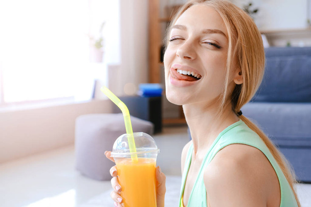 Sportos fiatal nő iszik friss gyümölcslé otthon - Fotó, kép