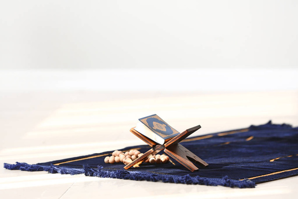 Corán y tasbih sobre la alfombra de oración musulmana
 - Foto, imagen