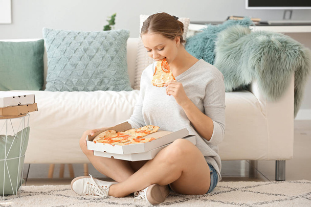 Gyönyörű nő eszik ízletes pizzát otthon - Fotó, kép