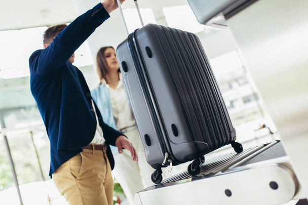 Les voyageurs d'affaires mettent leurs bagages sur une machine à rayons X tentent de les détecter
 - Photo, image