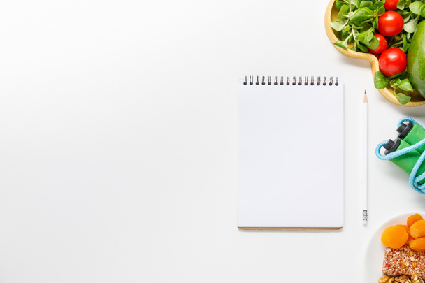 top view of blank notebook near diet food and skipping rope on white background - Foto, Bild