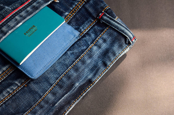 passport and wallet in jeans pockets isolated on black background - Photo, Image