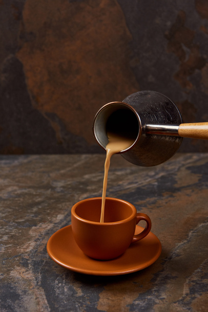 nalewanie kawy z dżezwa do filiżanki na powierzchni marmuru - Zdjęcie, obraz
