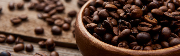 close up view of roasted coffee beans in bowl on wooden board, panoramic shot - Fotografie, Obrázek