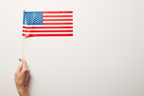 partial view of woman holding american flag on white background with copy space - Foto, imagen