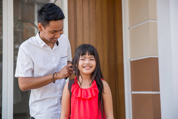 dad help her daughter to comb her hair - Photo, image