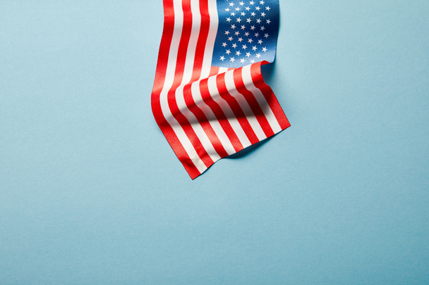 top view of american flag on stick on blue background with copy space - Photo, Image