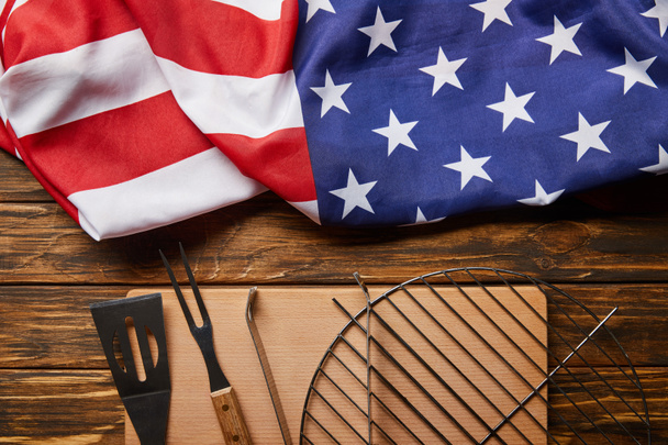 top view of crumpled american flag and bbq equipment on wooden rustic table - Photo, Image