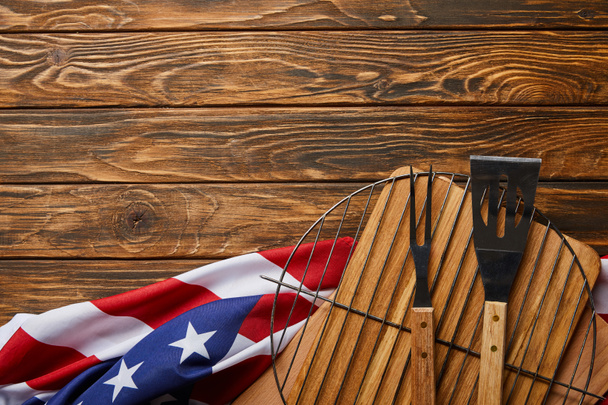 top view of crumpled american flag and bbq equipment on wooden rustic table with copy space - Photo, Image