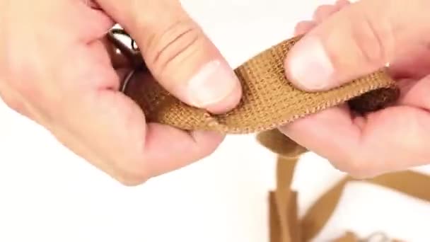 menselijke handen testen Bruine riem van de zak, op witte achtergrond - Video