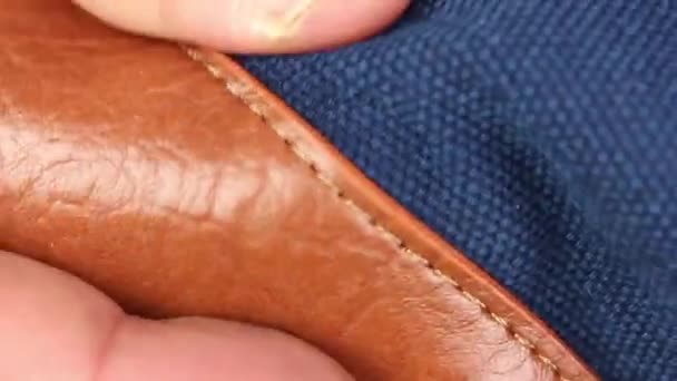 menschliche Hand prüft braunes Ledermaterial der Tasche, Boden  - Filmmaterial, Video