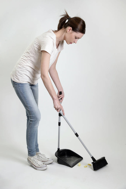 Mulher com vassoura e pá, equipamento de limpeza
 - Foto, Imagem