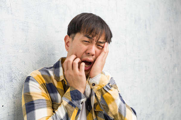junge chinesische Mann Gesicht Nahaufnahme verzweifelt und traurig - Foto, Bild