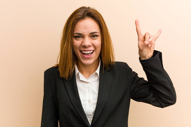Mladá běloška byznys žena ukazuje rohy gesto jako revoluční koncept. - Fotografie, Obrázek