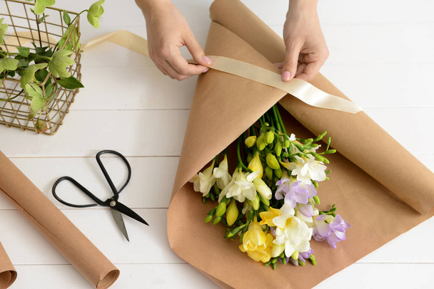 Florist making beautiful bouquet in shop - Foto, imagen