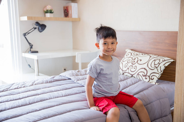boy sitting on a bed room - Foto, Imagem