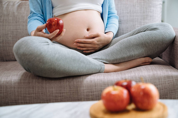 Ripe apple in hands of pregnant woman - Foto, Imagem
