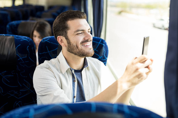 Усміхнений мандрівник фотографує на смартфоні під час перегляду через вікно
 - Фото, зображення