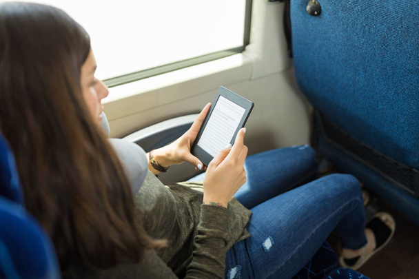 Young traveler reading e-book while sitting in bus - Foto, Bild