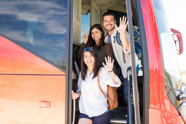 Retrato de amigos felices haciendo gestos en la entrada del autobús turístico
 - Foto, imagen