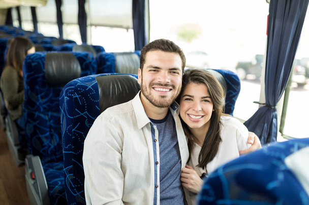 Portret uśmiechniętej Hiszpanów para siedzi ramię wokół w autobusie - Zdjęcie, obraz