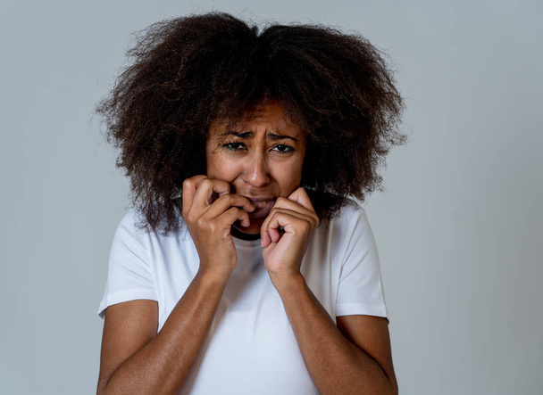 Portret van jonge Afro-Amerikaanse vrouw gevoel bang en geschokt maken angst, angst gebaren. Op zoek doodsbang bedekken zichzelf. Kopieer ruimte. In negatieve menselijke uitdrukkingen en emoties concept. - Foto, afbeelding