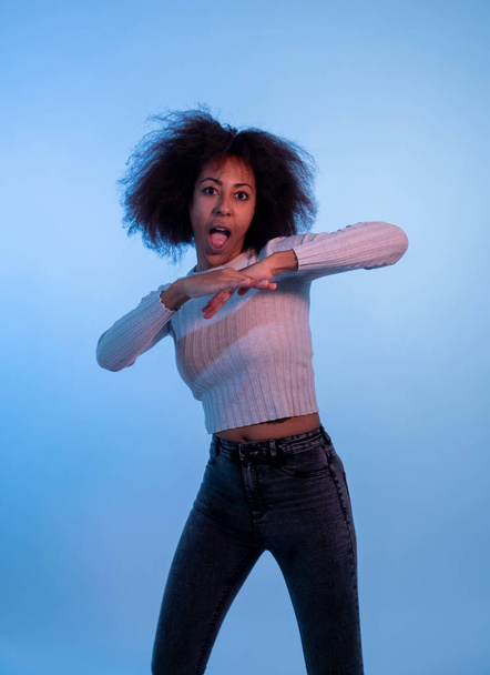 Portrait of inspired cool african american woman dancing feeling the music and enjoying life on blue moody disco light background. In People, Youth Party night lifestyle. Studio shot and copy space. - Foto, Imagen