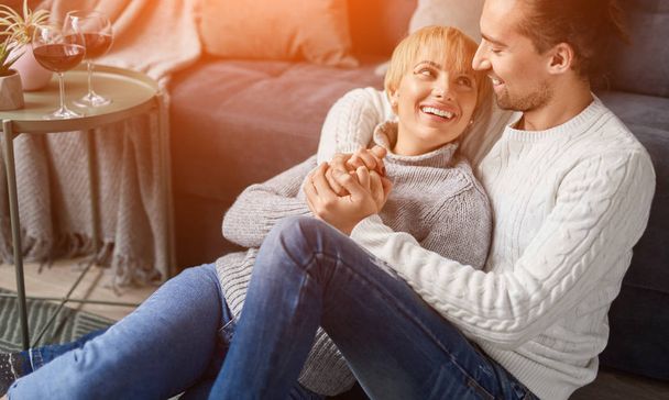 Happy couple hugging near couch during date - Фото, зображення