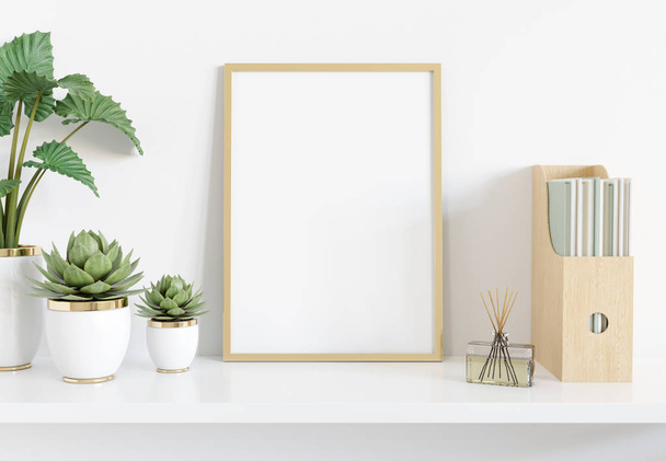 Golden frame leaning on white shelve in interior with plants and - Φωτογραφία, εικόνα