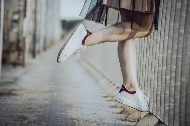 legs teen girl in white sneakers on the bridge. - Foto, Imagen